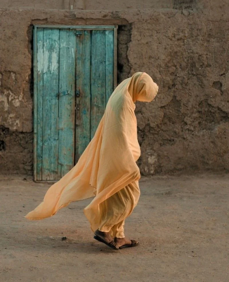 Femme dans le désert drapée de Melehfa traditionnelle